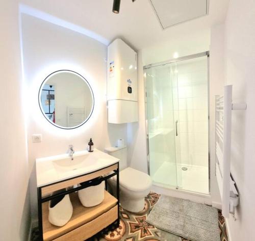 uma casa de banho com um lavatório, um WC e um espelho. em Grand studio avec terrasse - Gare - Metro - Wifi em Toulouse