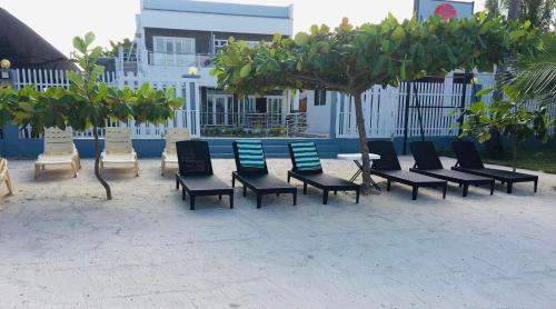 a group of chairs and a table and trees at Maykenn Beach in Bantayan Island