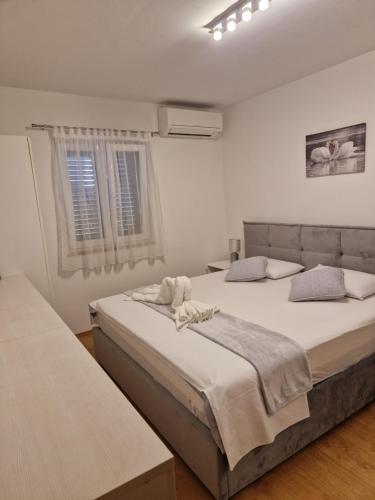 two beds in a white room with two windows at Apartment CHARLY in Supetar