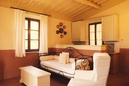 een kamer met een bed en twee stoelen. bij Poggio Cornetto in Bibbona