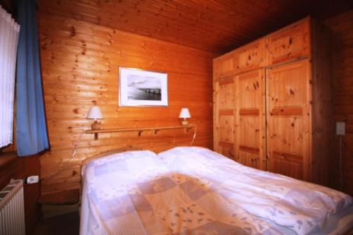 een slaapkamer met een bed in een houten hut bij Diekkieker - a90262 in Niederstrich