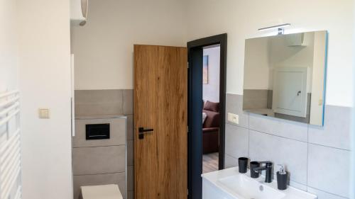 a bathroom with a sink and a mirror at Penzion Kamence in Liptovský Mikuláš