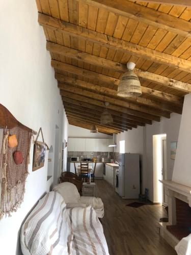 a living room with a bed and a living room with a kitchen at A Casa do Barqueiro- Alentejo in Pedrógão