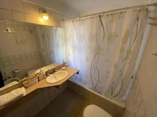 a bathroom with two sinks and a shower curtain at Departamento Necochea in Rosario