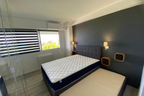Habitación pequeña con cama y ventana en Comfortable cocoon with exceptional sea view, en Vallauris