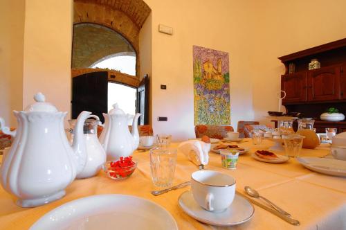サン・ジミニャーノにあるVilla Arnilùの白い花瓶と皿が置かれたテーブル