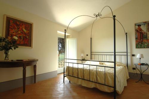 um quarto com uma cama de dossel e uma mesa em Villa Arnilù em San Gimignano