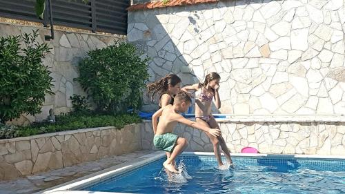 eine Gruppe von Kindern, die im Pool spielen in der Unterkunft Villa Tina in Ploče