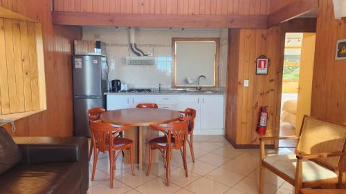 a kitchen with a table and chairs and a refrigerator at Hotel y Cabañas Lago Ranco - Caja los Andes in Futrono