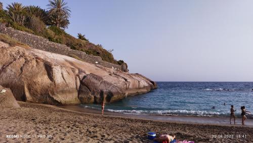 a group of people on a beach near the ocean at MNG-Apart Aloha Garden Costa Adeje in Adeje