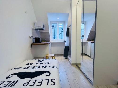 a small room with a bed and a glass door at Sur les Toits de Paris in Paris