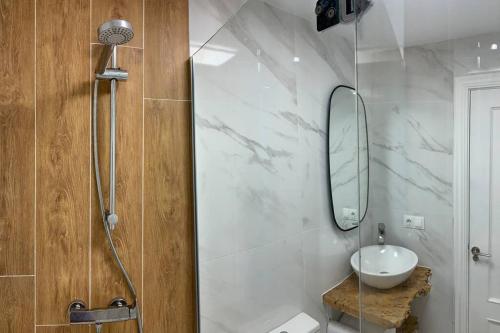 a bathroom with a sink and a shower with a mirror at Sunset Surf Sensations in Lariño