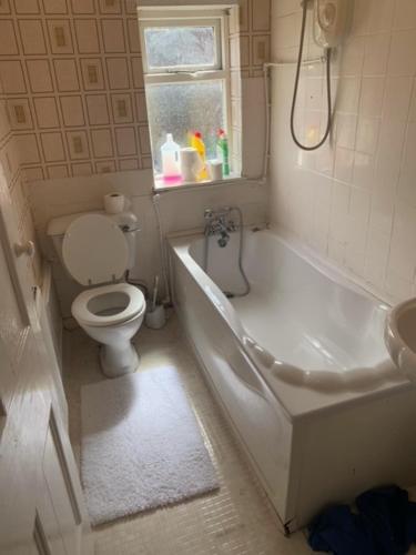 a bathroom with a toilet and a tub and a sink at Anfield view in Liverpool