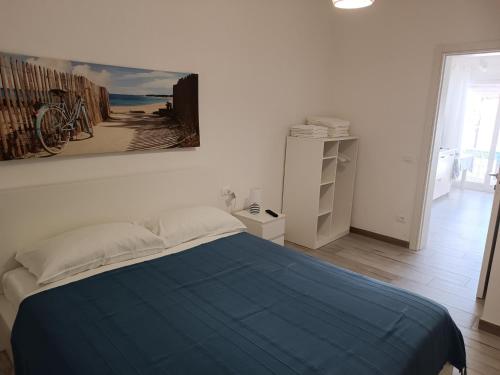 a bedroom with a bed with a blue blanket at Sabbia d'oro in Santa Maria Del Focallo