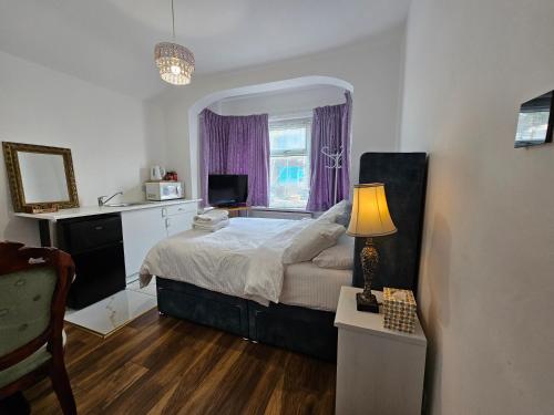1 dormitorio con 1 cama y 1 mesa con lámpara en Lovely Rooms London en Londres