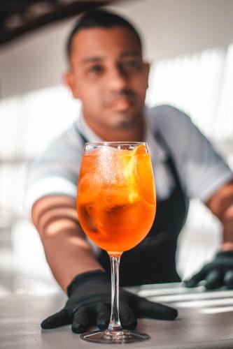 a man sitting at a table with a drink at Serena Buzios in Búzios