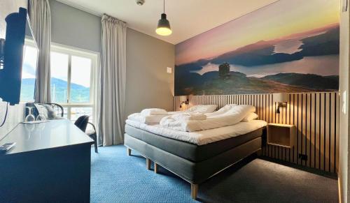 1 dormitorio con 1 cama con una pintura en la pared en Ryfylke Fjordhotel en Sand