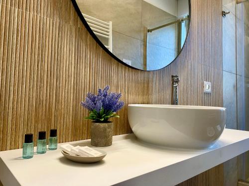 ein Badezimmer mit einem weißen Waschbecken und einem Spiegel in der Unterkunft Luna Nuova Suites in Neapel