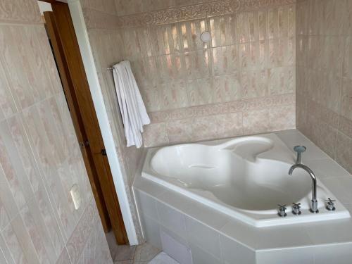 La salle de bains est pourvue d'une baignoire blanche. dans l'établissement Hotel Neptuno Refugio, à Boca Chica
