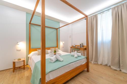 a bedroom with a canopy bed with towels on it at Mensos Rooms in Olbia