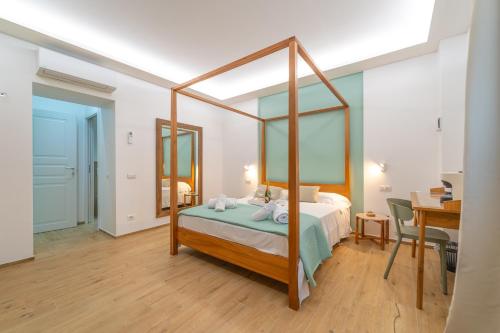 1 dormitorio con cama con dosel y escritorio en Mensos, en Olbia