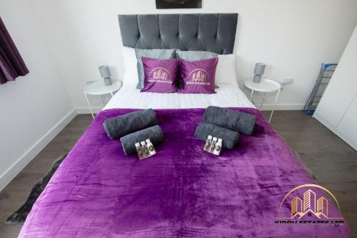 un letto viola con lenzuola e cuscini viola; di Dionysus Apartment - The Celebration of Town a Southampton
