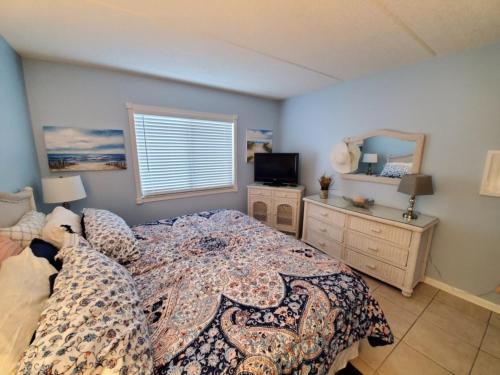 1 dormitorio con 1 cama, TV y ventana en St Augustine Ocean and Racquet 3102 en Saint Augustine