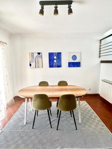uma sala de jantar com uma mesa de madeira e 2 cadeiras em casa de praia em Charneca