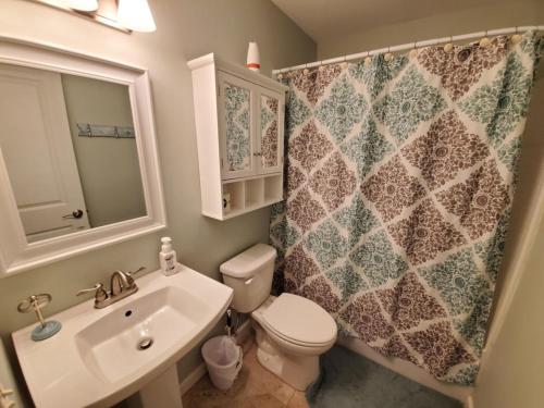 uma casa de banho com um lavatório, um WC e um espelho. em Floridays em Saint Augustine Beach
