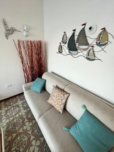a living room with a couch with pillows on it at Finestra sul mare in Monfalcone