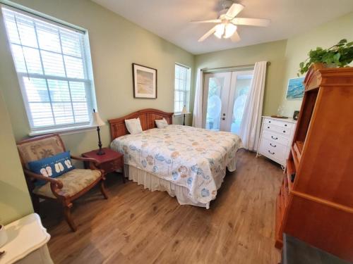 um quarto com uma cama e uma cadeira em Treasure Beach em Saint Augustine