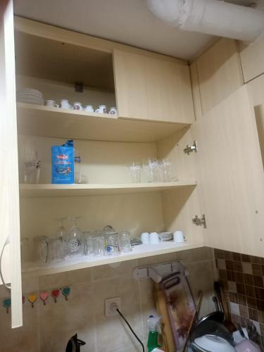 a kitchen with shelves with dishes and glasses at Daire in Kuşadası