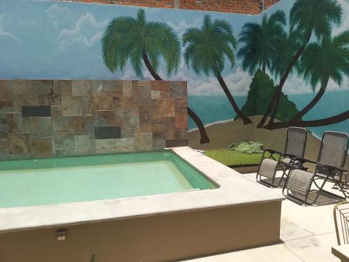 a swimming pool with chairs and a mural of a beach at Casa Lana Central in Ajijic