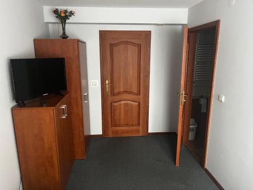 una stanza con una porta e una televisione su un armadio di Zajazd Herbu Wielbut a Łomża