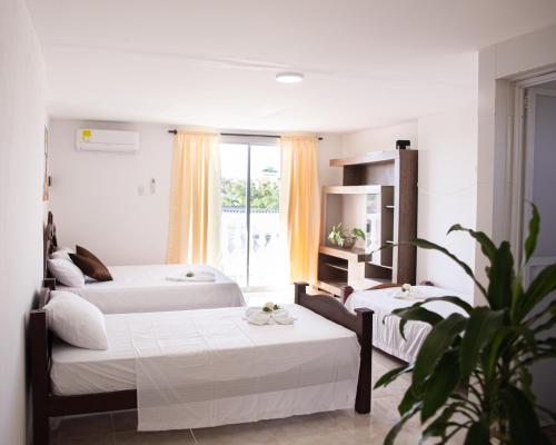 een hotelkamer met 2 bedden en een raam bij La Niña Mire in Puerto Colombia