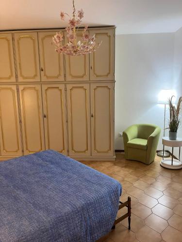 a bedroom with a bed and a chair and a chandelier at Finestra sul mare in Monfalcone