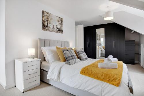 a bedroom with a white bed with a yellow blanket at Terrace View Home in South Shields, Sleeps 7 in South Shields
