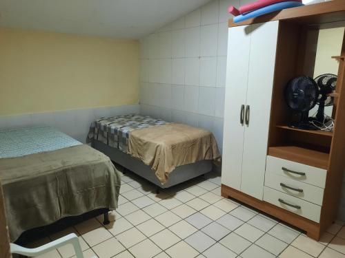 a room with a bed and a dresser in it at Casa Frio da Serrinha Gravatá in Gravatá