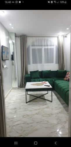 sala de estar con sofá verde y mesa de centro en Heart of tangier, en Tánger
