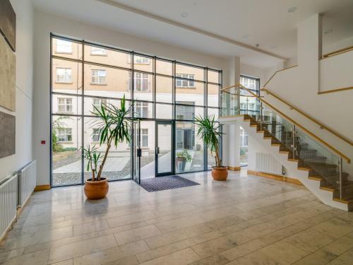 an empty hallway with stairs and potted plants at Central Belfast Apartments Alfred Street in Belfast