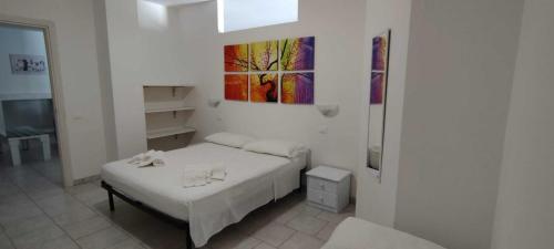 a bedroom with a bed and a painting on the wall at Salentum Villa Miami - con ampia terrazza in Vignacastrisi