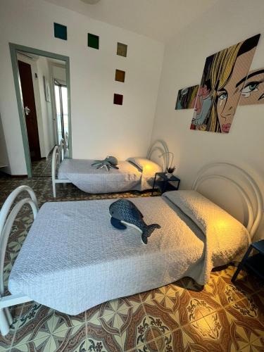 a bedroom with two beds and a painting on the wall at Finestra sul mare in Monfalcone