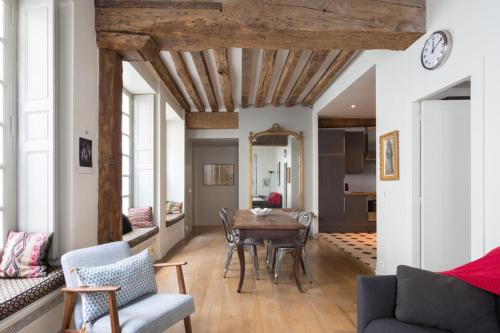 un salon avec une table et des chaises dans l'établissement Charming Appartment in Le Marais, à Paris