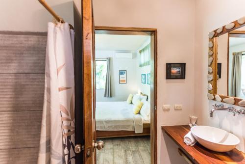 a bathroom with a sink and a mirror at Ohana Villas in Santa Teresa Beach