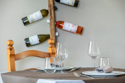 a table with glasses and wine bottles on a wall at Agriturismo Cantine Bevione - Rooms with air conditioning in Belvedere Langhe