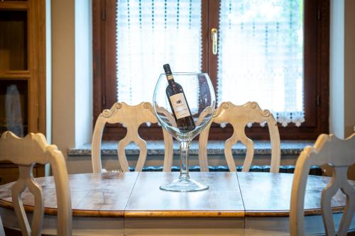 a wine glass sitting on a table with two chairs at Agriturismo Cantine Bevione - Rooms with air conditioning in Belvedere Langhe