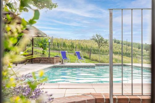 - deux chaises bleues installées à côté de la piscine dans l'établissement Agriturismo Cantine Bevione - Rooms with air conditioning, à Belvedere Langhe