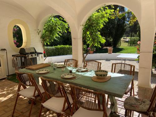 een tafel en stoelen in een patio met een tafel en een stoeltje bij Casa dos Arcos - Penina Villa in Portimão