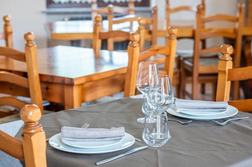 a table with plates and glasses on top of it at Agriturismo Cantine Bevione - Rooms with air conditioning in Belvedere Langhe