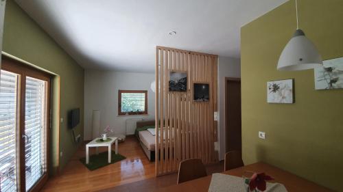 a room with a bedroom with a bed and a table at Apartments Tourist Farm Štorman with EV Ch-Station in Tržič